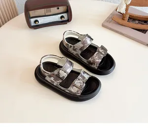 Detail view of camouflage kids sandals with adjustable straps on a minimalist tabletop
