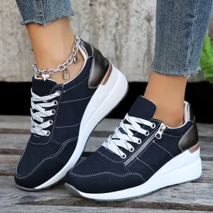 Λεπτομέρεια από μπλε σκούρα sneakers με πλατφόρμα, πλαϊνό φερμουάρ και λευκή σόλα.