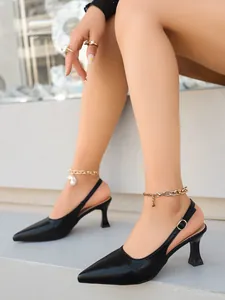 Escarpins noirs élégants à bout pointu et bride arrière portés par un mannequin