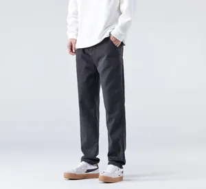 Vue en contre-plongée d'un jean large gris foncé pour homme avec des baskets