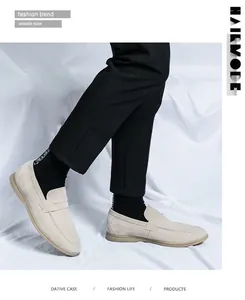 Detail view of beige suede penny loafers on model with white fabric background