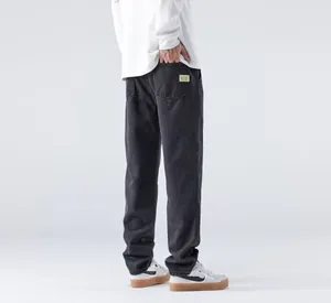 Vue arrière détaillée d'un jean noir large pour homme avec étiquette sur la poche arrière