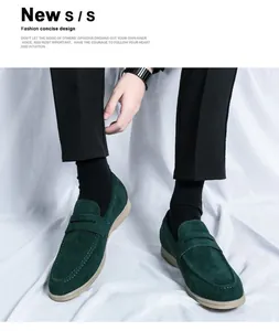 Detail view of stylish men's dark green suede penny loafers worn with black trousers