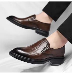Detail van bruine herenschoenen van leer met krokodillentextuur en een gepolijste neus