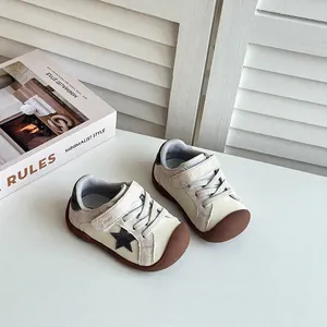 Stylish minimalist toddler sneakers in cream and brown featuring a black star accent