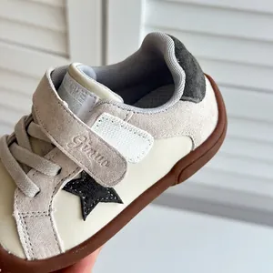 Detailed macro shot of beige toddler skate shoe with black star patch and velcro