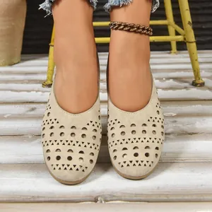 Detailaufnahme der beigen flachen Schuhe mit lasergeschnittenem Lochmuster-Design