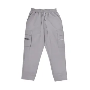 Macro detail view of grey loose fit cargo sweatpants with drawstring and zippered pockets.