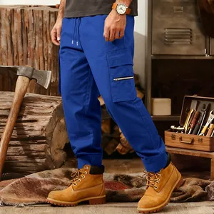 Detailed view of blue multi-pocket cargo sweatpants in a rustic outdoor workshop