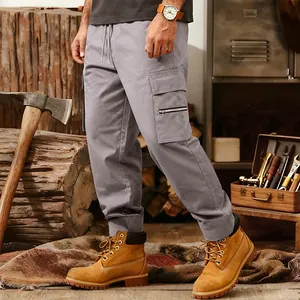 Detail of men's loose tactical cargo pants with multi-pockets in a rustic workshop