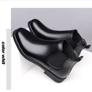 Detail view of men's black pointed-toe leather Chelsea boots on a white display stand