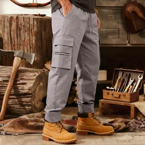 Detail of men's gray tactical cargo pants with multiple pockets in a rugged setting.