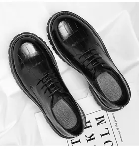 Détail de chaussures en cuir noir à plateforme pour hommes avec texture croco et bout rond