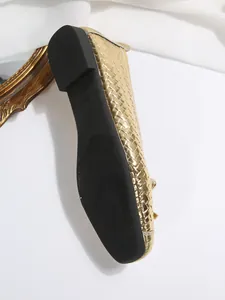 Detail view showing the black sole and golden woven texture of these French ballet flats
