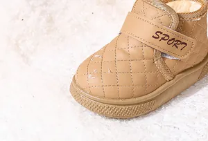 Primer plano de botas de nieve acolchadas para niños con forro de felpa y velcro.