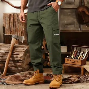 Close-up detail of olive green multi-pocket tactical cargo pants in a workshop.