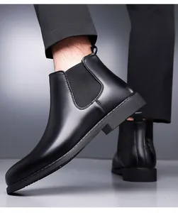 Close-up of premium black leather Chelsea boot with elastic side panel worn by model