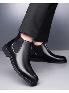 Close-up of men's black leather Chelsea boots with pointed toe and elastic panels