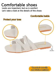 Detail view of stylish white open-toe slide sandals with cross-straps design.