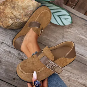 Vue détaillée des mocassins de style Birkenstock en daim marron avec boucle métallique