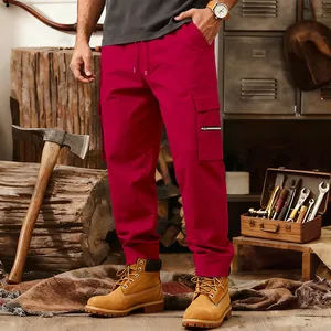 Detail of men's red cargo joggers with multi-pockets in a rugged workshop scene