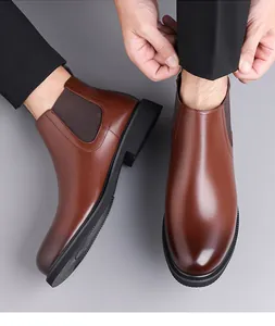 Detailed view of brown leather Chelsea boots with elegant stitching and elastic side panels.