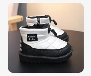 Close-up of waterproof kids snow boots with warm plush lining in black and white