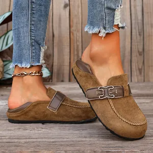 Gros plan de mules style Birkenstock en daim marron vintage avec un joli détail de boucle