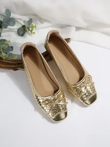 Detailed view of these French style gold woven ballet flats featuring elegant bow decoration