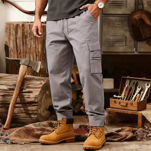 Detailed view of grey loose-fit multi-pocket cargo pants styled for a workwear aesthetic