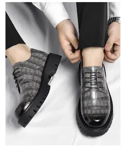 Gros plan de chaussures à plateforme grises pour hommes, texture crocodile et semelle épaisse