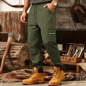 Detailed view of olive green tactical cargo pants with multiple pockets in workshop