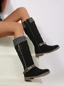 Close-up of black high-top boots with grey knitted cuff and side zipper detail