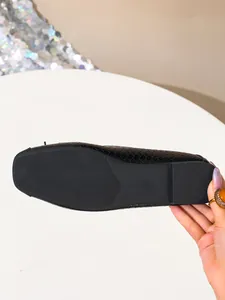 Detail showing the anti-slip sole and size mark of a black woven ballet flat