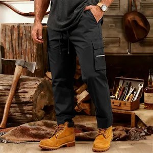 Men's loose black tactical cargo pants with multi-pockets shown in a vintage workshop setting