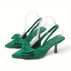 Πλαϊνή όψη κομψών πράσινων slingback γοβών με διπλό φιόγκο και μυτερή μύτη.
