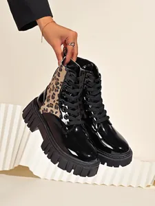 Detail of leopard print Martin boots with black patent leather and chunky lug sole