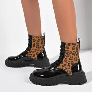 Detail view of leopard print Martin boots with black patent leather and lug sole