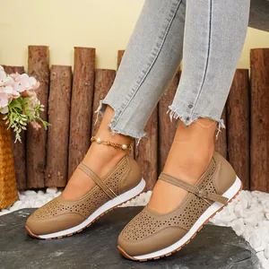 Primer plano de los zapatos Mary Jane beige con patrones florales cortados con láser