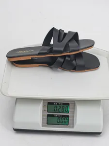 Close-up view of black open-toe casual sandals being weighed on a scale at 0.28kg