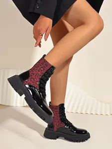 Detailed side view of women's leopard print panel combat boots with patent leather