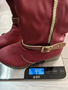 Detail von weinroten Damenstiefeln auf der Waage, die 446g für leichten Komfort wiegen.