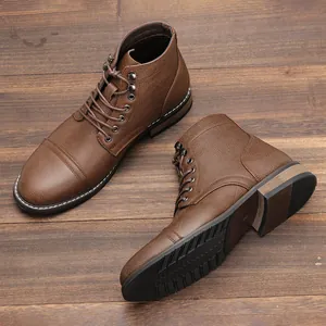 Primer plano detallado de botas de trabajo marrones retro para hombre en madera