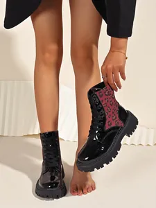 Detail showing leopard print fabric and shiny patent leather on chunky sole Martin boots