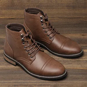 Vista detallada de botas de trabajo para hombre en cuero marrón vintage sobre madera.