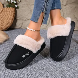 Close-up of black winter slippers with plush faux fur trim and SPORT embroidery.