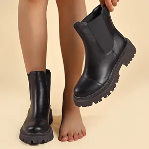 Close-up detail shot of black chunky platform Chelsea boots with elastic side panels.