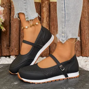 Primer plano de zapatos Mary Jane negros perforados con correa de hebilla y suela de goma