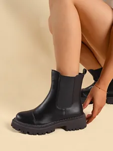 Detailed view of black round-toe Chelsea boots with a thick lug sole