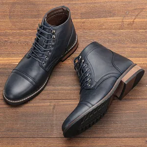 Vista superior de botas Martin de cuero azul marino para hombre en suelo de madera.